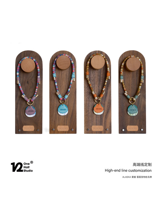 Beaded dog collars with round name tags on wooden display stands