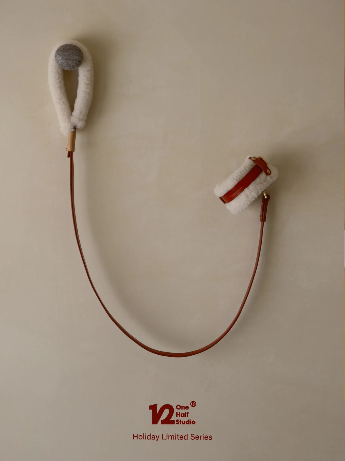 Red leather leash coiled on a wall hook