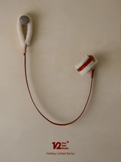 Red leather leash coiled on a wall hook