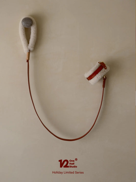 Red leather leash coiled on a wall hook