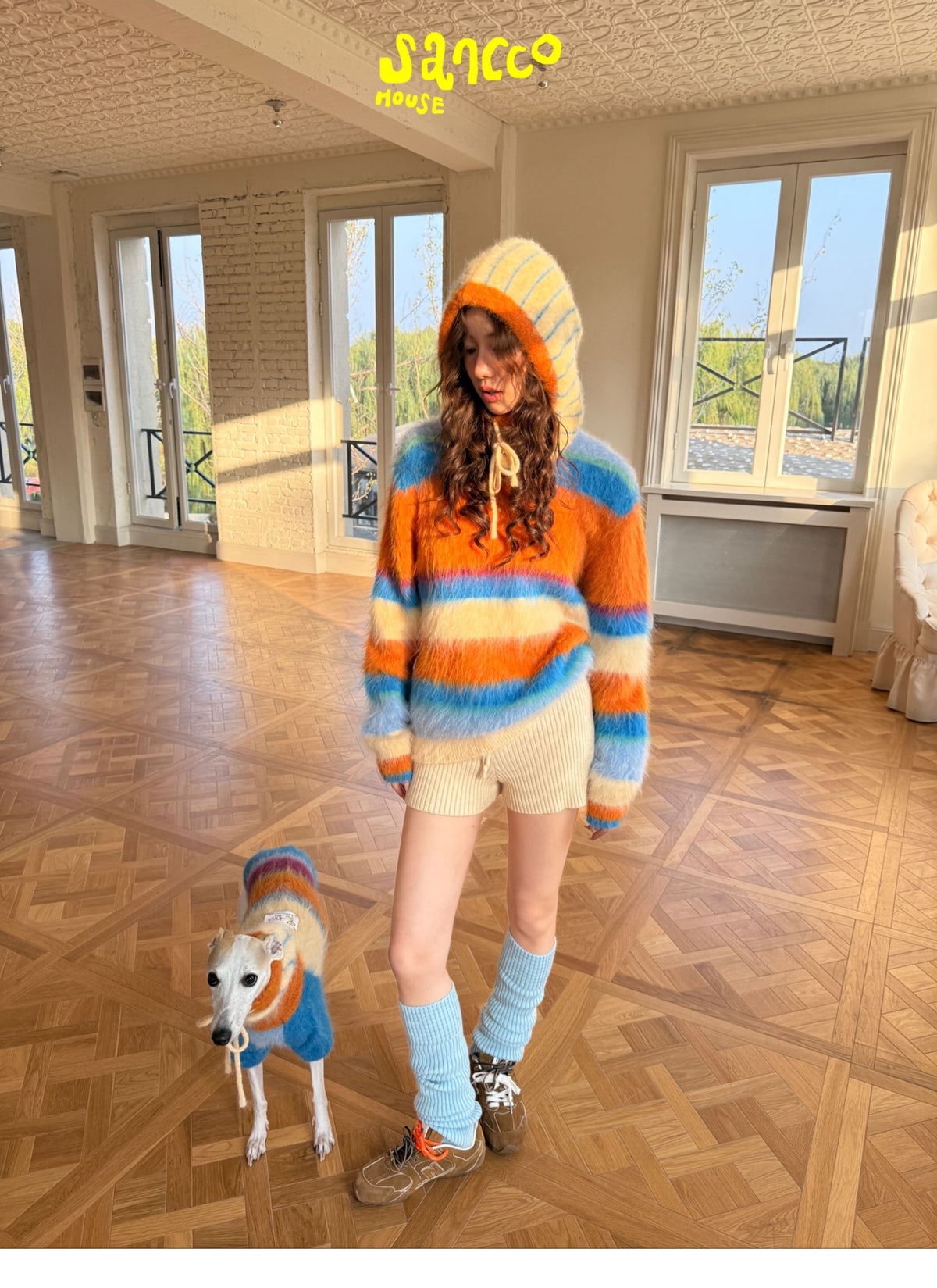 Woman walking a dog in matching knitted hats