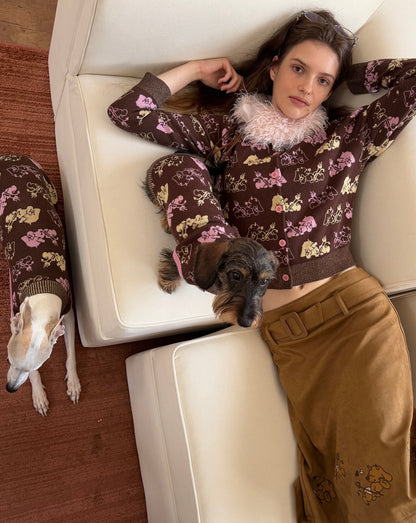 Woman reclining on a sofa in the brown dog jacquard cardigan, a dachshund and a whippet in matching knits beside her