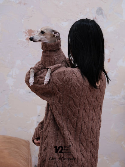 Parent holding a whippet in an ebony brown knit sweater