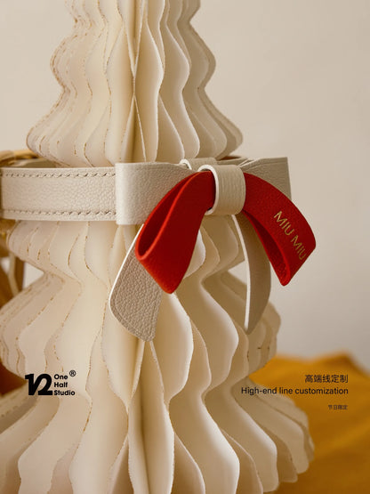 Pair of red bow collars on a pale tree sculpture