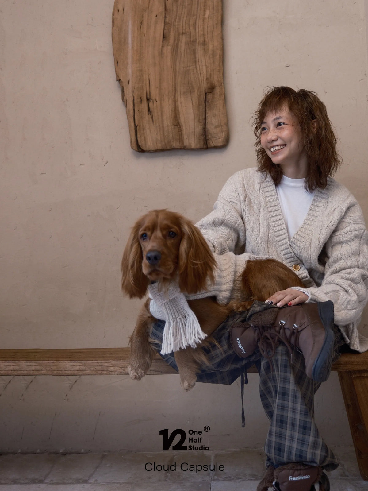 Parent holding a dog in a cream cable knit sweater